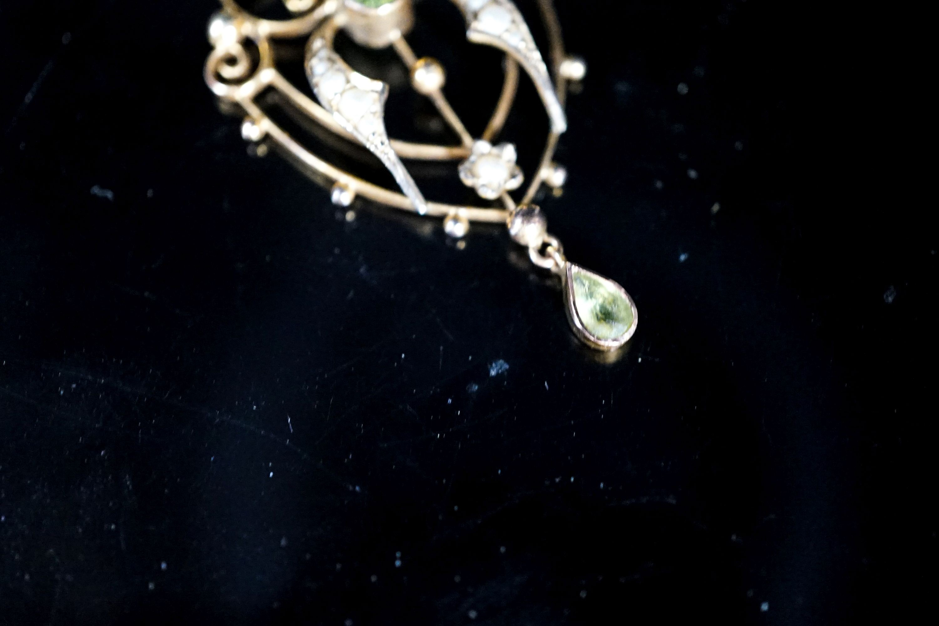 An Edwardian 9ct, peridot and seed pearl set drop pendant, 42mm, on a 9ct chain, 49cm
